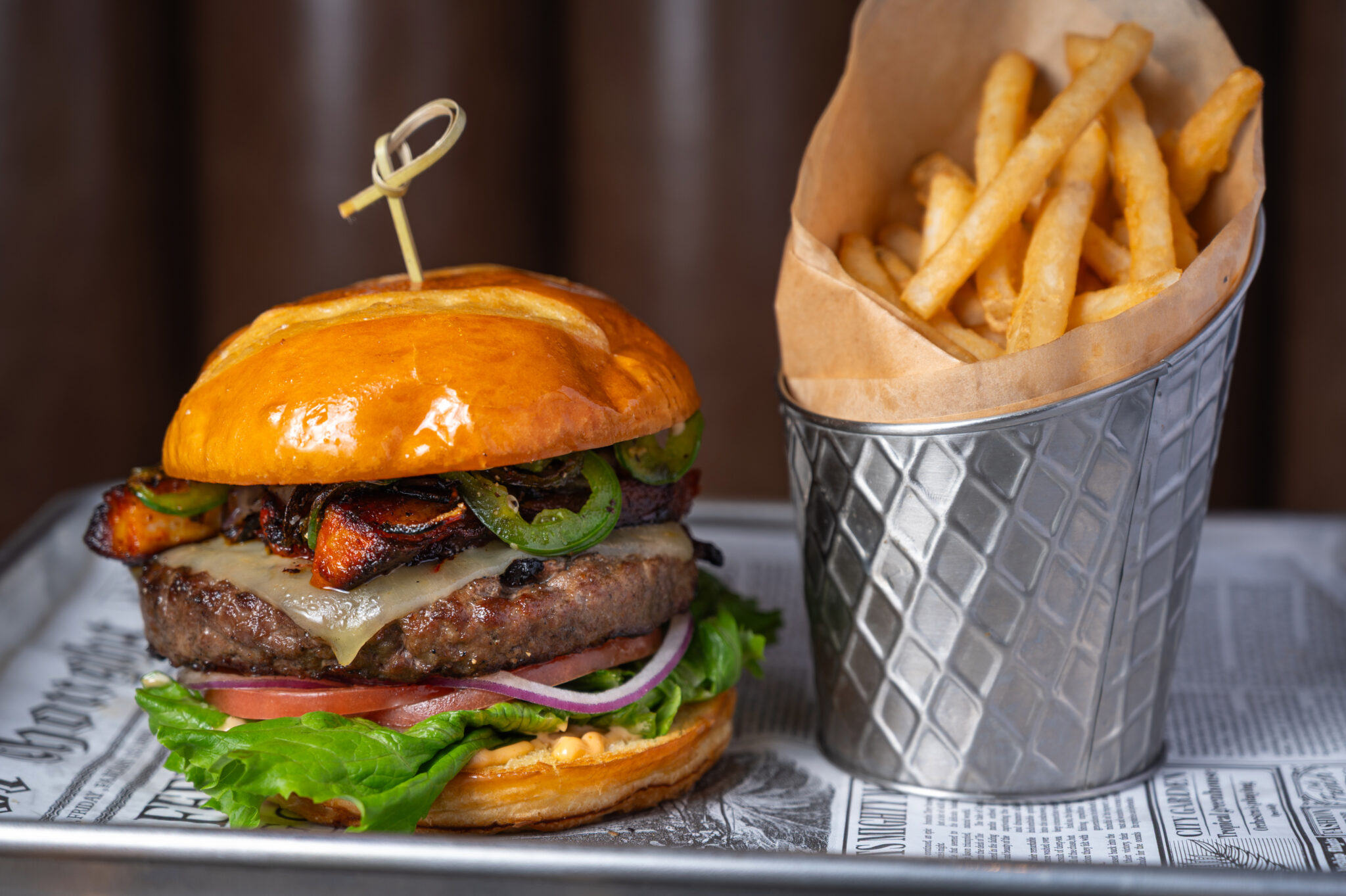 Gourmet bacon cheeseburger with grilled onions and fresh lettuce at The Bridewell Tavern