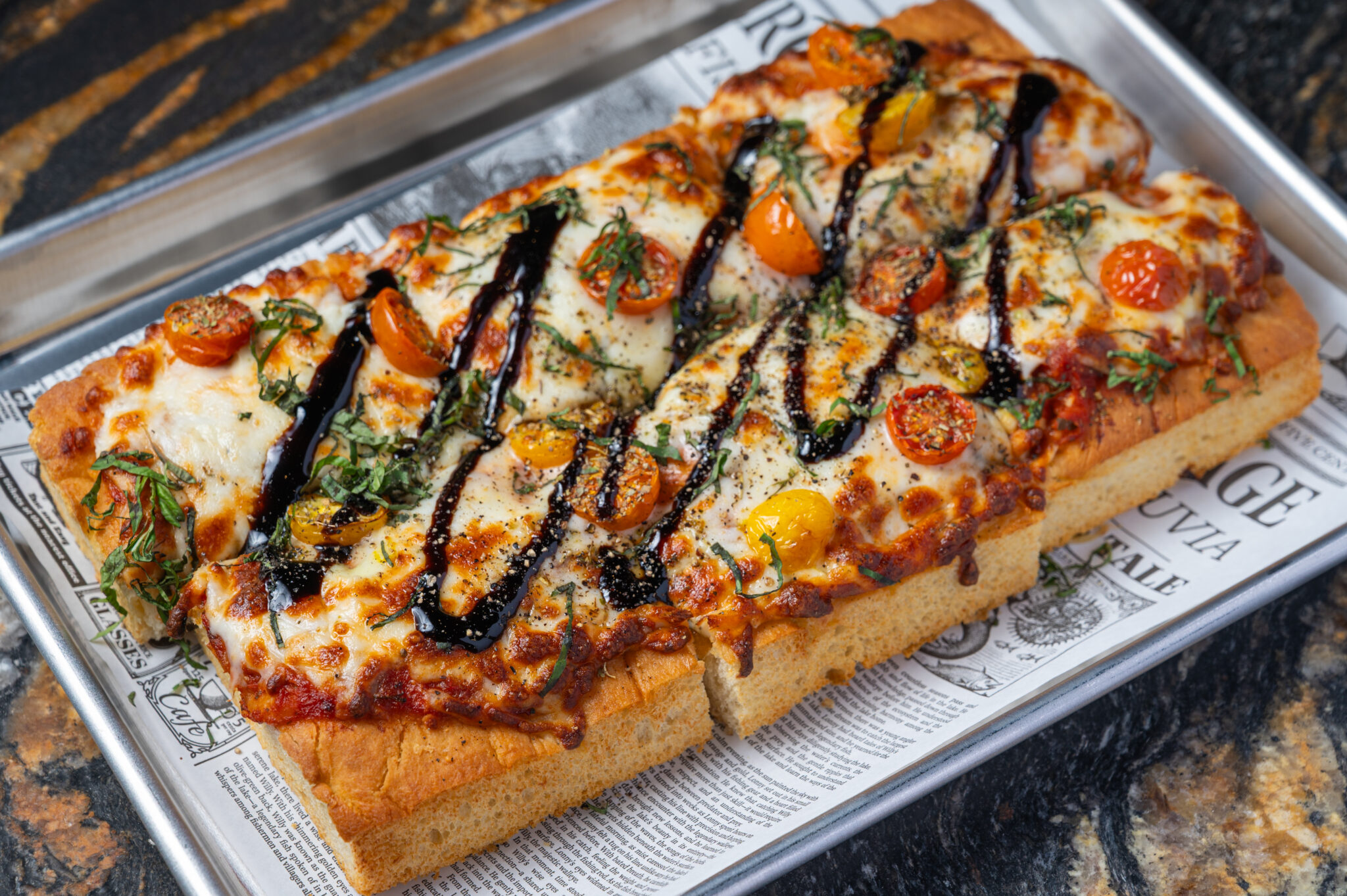 Tuscan flatbread pizza with fresh mozzarella, blistered cherry tomatoes, basil and balsamic glaze